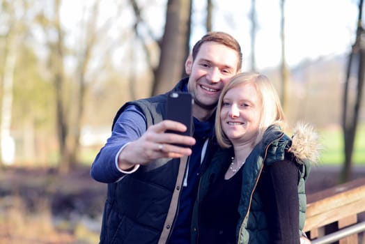 young woman and man in the park taking a sel-portait