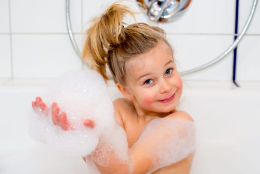 little funny girl with foam bathtub in the bathtub