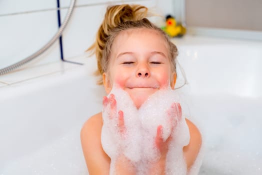 little funny girl with foam bathtub in the bathtub