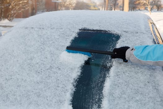 Snow being cleared off from a car front window