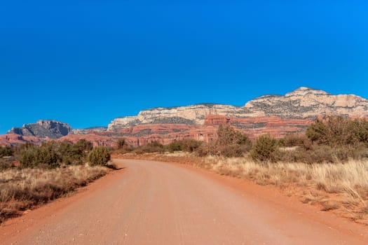 Landscape of a road going through red rock scenery in Sedona, Arizona.