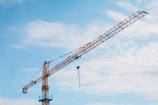 Yellow crane and blue sky on building site
