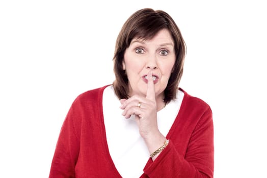 Woman gesturing silence against white background