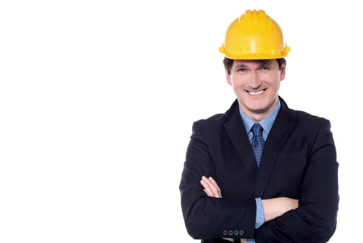 Businessman posing with folded arms wearing safety helmet