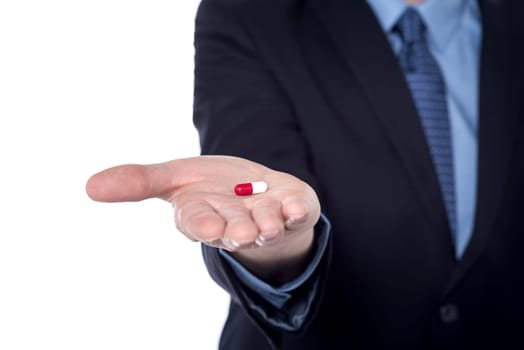 Cropped image of a businessman holding pill in his hand