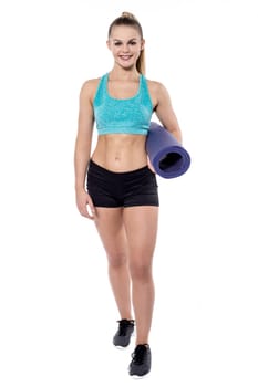 Young woman posing with exercise mat