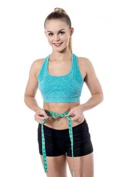 Fit lady measuring her waist