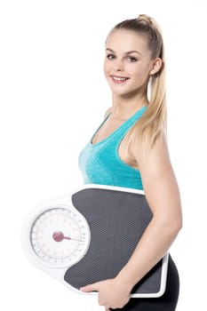 Beautiful trainer posing with weighing machine