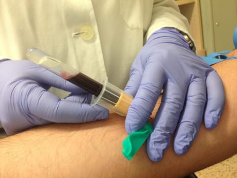 Nurse taking a blood sample from patient. Closeup