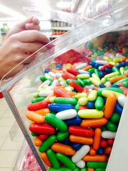 Woman serving herself sweets with shovel at supermarket