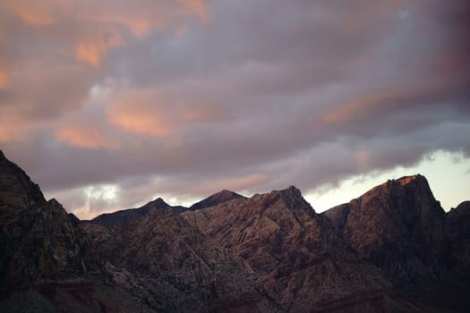 A rugged mountain range between Amargosa Valley and Las Vergas during a sunset.