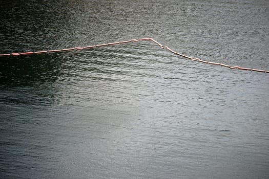 A chain of floating buoys serves as a barrier or demarcation.