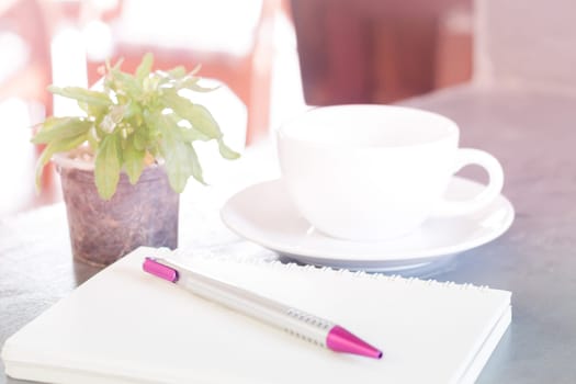 Notepad, pen and green plant on grey background, stock photo