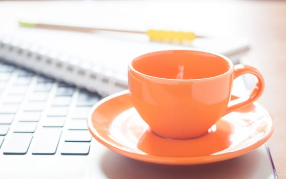 Laptop with coffee cup and notepad on desk, stock photo
