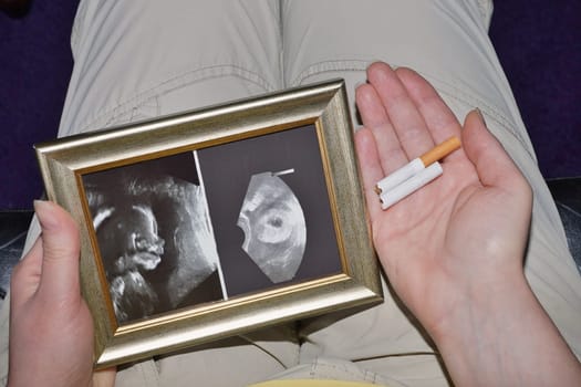 Pregnant woman with ultrasound image and broken cigarette