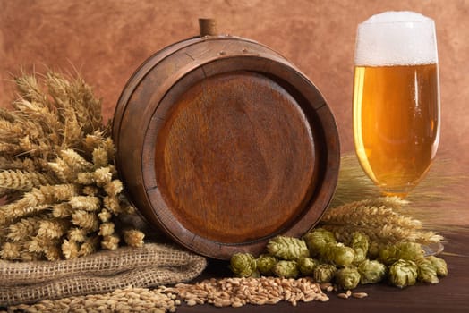 Old wooden barrel with beer glass,wheat,barley,hops and malt