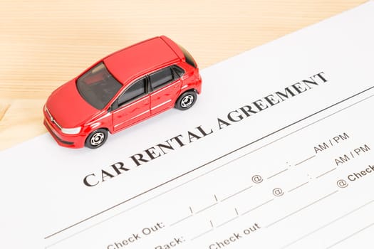 Car rental agreement with red car on left view. Auto rental agreement or legal document