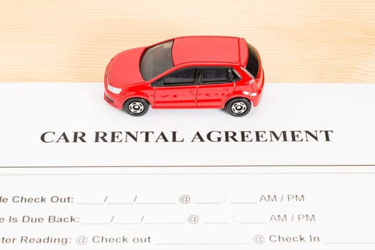 Car rental agreement with red car on center. Auto rental agreement or legal document