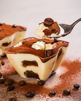 Tiramisu dessert with coffee beans on modern table. Italian sweet dessert concept..