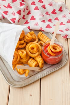 Twisted fries in paper tuete with ketchup