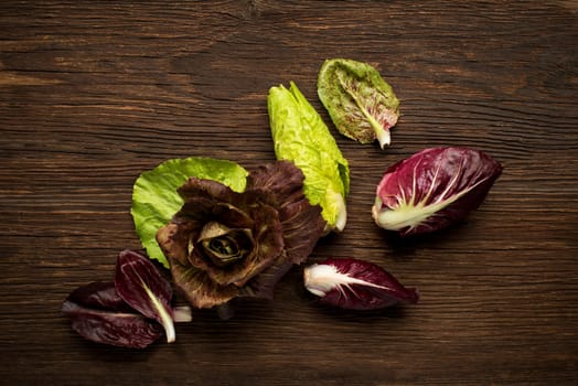 Fresh mixed radicchio on a wooden background.
