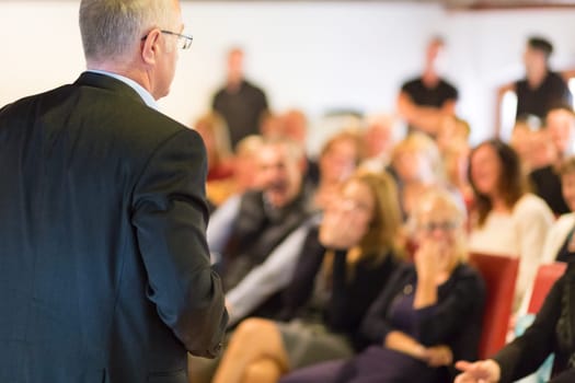 Speaker at Business Conference with Public Presentations. Audience at the conference hall. Entrepreneurship club. Rear view. Horisontal composition. Background blur.
