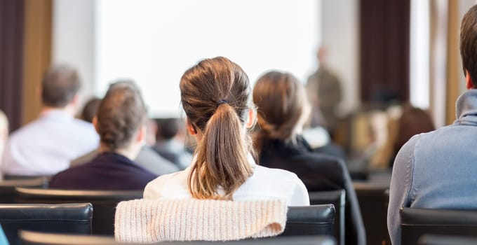 Speaker Giving a Talk at Business Meeting. Audience in the conference hall. Business and Entrepreneurship. Panoramic composition suitable for banners.