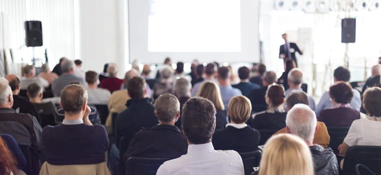 Speaker Giving a Talk at Business Meeting. Audience in the conference hall. Business and Entrepreneurship. Panoramic composition suitable for banners.