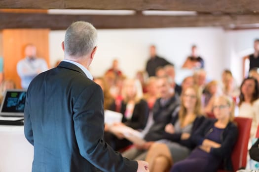 Speaker at Business Conference with Public Presentations. Audience at the conference hall. Entrepreneurship club. Rear view. Horisontal composition. Background blur.