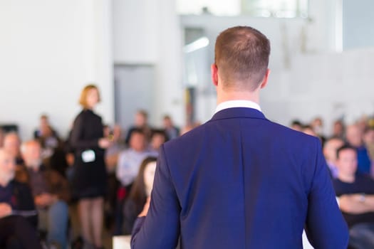 Speaker at Business Conference with Public Presentations. Audience at the conference hall. Business and Entrepreneurship concept. Background blur. Shallow depth of field.