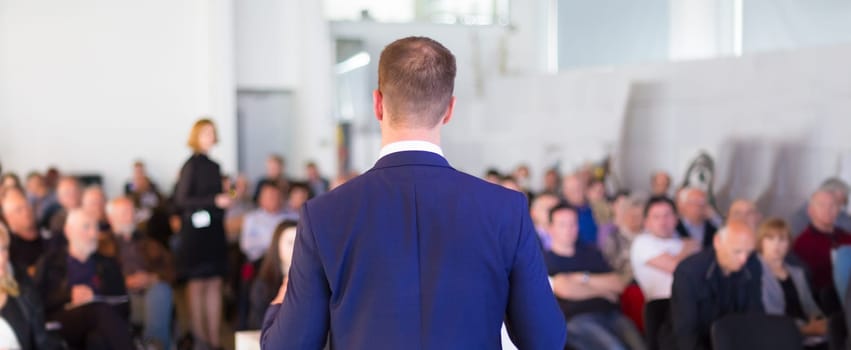 Speaker at Business Conference with Public Presentations. Audience at the conference hall. Business and Entrepreneurship concept. Background blur. Shallow depth of field.