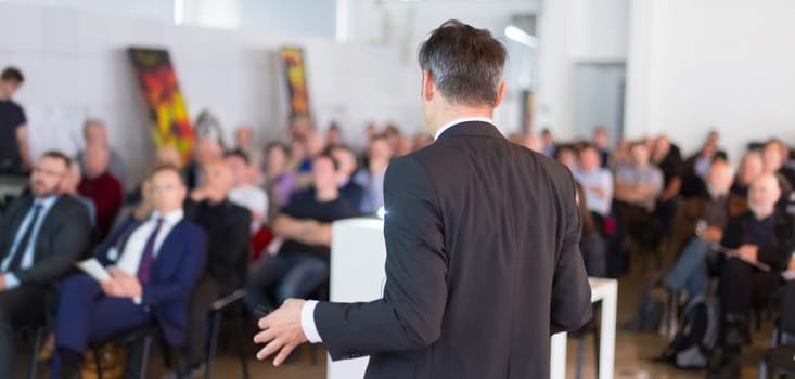 Speaker at Business Conference with Public Presentations. Audience at the conference hall. Business and Entrepreneurship concept. Background blur. Shallow depth of field.