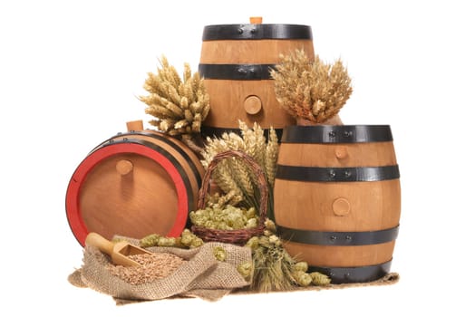 three old beer barrels insulated with wheat,barley,hops and malt On White