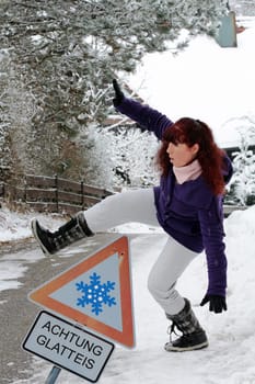 Attention Accident danger in winter - A woman slips on a snow-smooth road