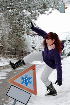 Attention Accident danger in winter - A woman slips on a snow-smooth road