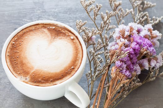 Coffee cup with beautiful violet flower, stock photo