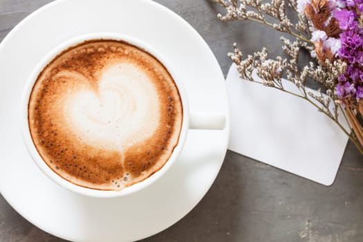 Coffee cup with name card on grey background, stock photo