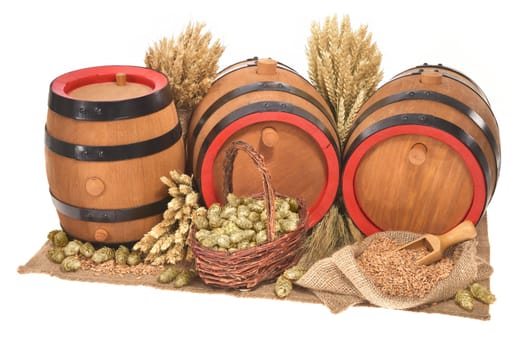 three old beer barrels insulated with wheat,barley,hops and malt On White