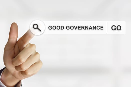business hand clicking good governance button on search toolbar with blurred background