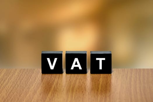 VAT or value added tax on black block with blurred background