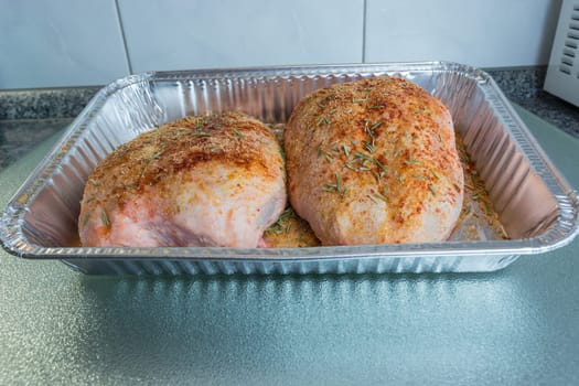 Raw duck breast seasoned in an aluminum bowl.
