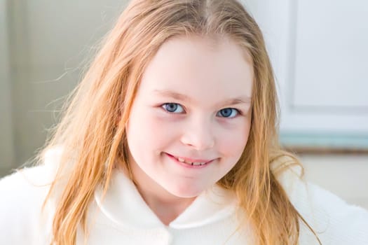 Portrait of cute girl with blond hair in white