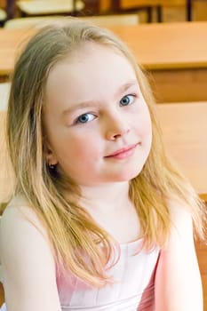 Portrait of cute younger schoolgirl with blond hair