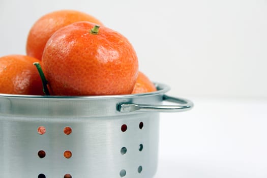 Mandarins in kitchen sieves
