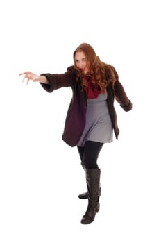 A very active young woman dancing in a winter coat and boots, isolated.for white background..