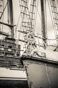 Old collapsing sailboats at the dock, close-up, sepia