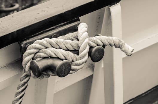 Rope tied to bollard sailboat, sepia