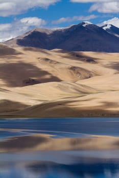 Tsomoriri mountain lake panorama with mountains and blue sky reflections in the lake (north India)