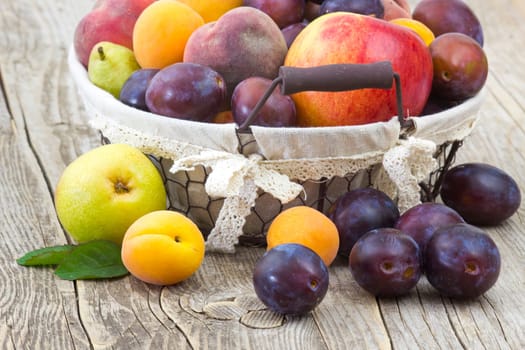 fresh fruits in a basket on wooden background