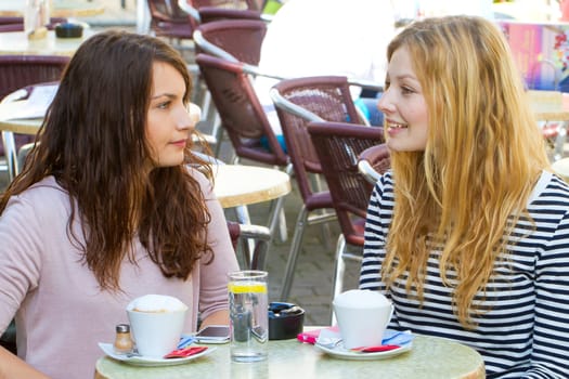 Two young women in the street cafe